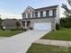 Beautiful two-story home with brick and siding, a well-manicured lawn, and an attached two-car garage at 8901 Powder Works Dr, Huntersville, NC 28078