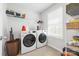 Well-lit laundry room with washer, dryer, shelving, and window at 8901 Powder Works Dr, Huntersville, NC 28078