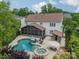 Aerial view of a home with a sparkling pool, patio, outdoor kitchen and screened in porch at 8902 Whittingham Dr, Waxhaw, NC 28173