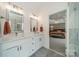Bathroom with dual sinks, modern fixtures, and a view to the main bedroom at 8902 Whittingham Dr, Waxhaw, NC 28173