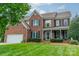 Charming brick home featuring a well-manicured lawn, a two-car garage, and classic black shutters at 8902 Whittingham Dr, Waxhaw, NC 28173