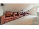 Cozy home theater featuring comfortable leather recliner seating, projector, and carpeted floor at 8902 Whittingham Dr, Waxhaw, NC 28173