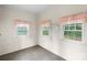 Bright bedroom featuring wood paneled walls, multiple windows, and a vintage shelf at 8903 Larchmont Cir, Charlotte, NC 28214