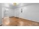 Bright bedroom with hardwood floors, natural light from window, and white painted walls at 8903 Larchmont Cir, Charlotte, NC 28214
