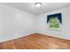 Hardwood floors and bright window in this serene and minimalist bedroom at 8903 Larchmont Cir, Charlotte, NC 28214