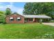 Traditional brick ranch home with green lawn, covered porch, and attached carport, offering curb appeal at 8903 Larchmont Cir, Charlotte, NC 28214