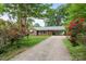 Charming brick home featuring a long driveway, lush landscaping and beautiful flowers framing the entrance at 8903 Larchmont Cir, Charlotte, NC 28214