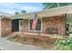 Inviting front porch with brick detail, showcasing an American flag, bench, and tidy landscaping at 8903 Larchmont Cir, Charlotte, NC 28214