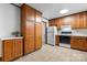 Well-maintained kitchen with wood cabinets, functional appliances, and durable tile flooring at 8903 Larchmont Cir, Charlotte, NC 28214