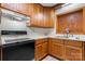 Kitchen featuring wood cabinets, white appliances and tile floor offering functionality and practicality at 8903 Larchmont Cir, Charlotte, NC 28214