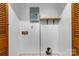 Neutral laundry room features wood slated closet doors and a small shelf for storage at 8903 Larchmont Cir, Charlotte, NC 28214