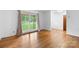 Hardwood floors in an empty room featuring large window and neutral paint, creating a serene space at 8903 Larchmont Cir, Charlotte, NC 28214