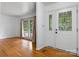 Bright living room featuring hardwood floors, large windows, and a decorative front door at 8903 Larchmont Cir, Charlotte, NC 28214