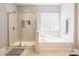 Bright bathroom showcases glass enclosed shower, soaking tub, and a large window at 924 Forbes Rd, Fort Mill, SC 29707