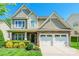 Front exterior of home with stone accents, manicured landscaping, a two-car garage, and a welcoming front porch at 924 Forbes Rd, Fort Mill, SC 29707