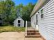 Backyard with a shed, patio, and steps up to the side door of the house at 113 Burke Cir, Mooresville, NC 28115