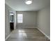 This bedroom features neutral walls, wood look floors and an open door to bathroom at 113 Burke Cir, Mooresville, NC 28115