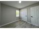 This bedroom features neutral walls, wood look floors and a white door with black hardware at 113 Burke Cir, Mooresville, NC 28115