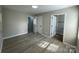 This bedroom features neutral walls, wood look floors and two open white doors at 113 Burke Cir, Mooresville, NC 28115