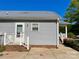 Side view of a single story home with light gray siding, metal roof, and brick foundation at 113 Burke Cir, Mooresville, NC 28115