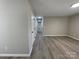 Hallway with neutral paint, showing access to bedrooms and bathrooms and continuous new flooring at 113 Burke Cir, Mooresville, NC 28115