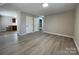 Open living room featuring sleek floors, neutral walls, recessed lighting, and access to the kitchen and bathroom at 113 Burke Cir, Mooresville, NC 28115