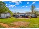 Wide shot of backyard with grassy lawn, deck with furniture, and storage buildings at 114 Doubletree Dr, Statesville, NC 28677