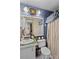Compact bathroom featuring a vanity with sink, toilet, and textured blue wallpaper at 114 Doubletree Dr, Statesville, NC 28677