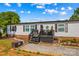 Welcoming front porch with black railings and decor, complemented by a beautifully landscaped front yard at 114 Doubletree Dr, Statesville, NC 28677