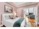 Bedroom featuring a plush white bed, soft grey pillows, and a blue throw blanket with living room access at 127 N Tryon St # 511, Charlotte, NC 28202