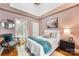 Comfortable bedroom with a white bed, grey pillows, blue blanket, artwork, chair, and bathroom access at 127 N Tryon St # 511, Charlotte, NC 28202