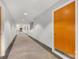Hallway view with light gray walls, carpet, and wood door with silver hardware at 127 N Tryon St # 511, Charlotte, NC 28202