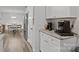 Open kitchen area with stainless steel refrigerator, white cabinets, granite counters and wood floors leading to dining area at 130 Cherokee Ln, Salisbury, NC 28147