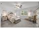 The main bedroom includes a sitting area, neutral walls, a ceiling fan, and bright natural light from the large window at 130 Cherokee Ln, Salisbury, NC 28147