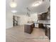 Spacious open kitchen featuring dark cabinets, stainless steel appliances, an island, and adjacent living area at 133 Stonewater Dr # 16P, Red Cross, NC 28129