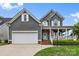 Charming two-story home boasts a welcoming front porch, neutral siding, a two-car garage, and well-maintained landscaping at 1358 Colwick Ln, Rock Hill, SC 29732