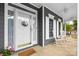 Charming front porch featuring rocking chairs, a white door with a wreath, and views of the well-maintained landscaping at 1358 Colwick Ln, Rock Hill, SC 29732