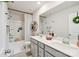 Modern bathroom featuring a double sink vanity, large mirror, and a shower-tub combo with stylish fixtures at 15813 Capps Rd, Charlotte, NC 28278