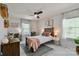 Comfortable bedroom with ceiling fan, desk and a bed with decorative pillows, complemented by natural light at 15813 Capps Rd, Charlotte, NC 28278