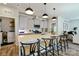 Bright kitchen with a large island, modern pendant lights, and gray cabinets, seamlessly flowing into the living space at 15813 Capps Rd, Charlotte, NC 28278