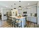 Spacious kitchen featuring a large center island with seating, gray cabinets, and stainless steel appliances at 15813 Capps Rd, Charlotte, NC 28278