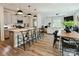 Open-concept kitchen featuring a large island with bar stools, gray cabinets, and modern pendant lighting at 15813 Capps Rd, Charlotte, NC 28278