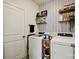 Efficient laundry room with modern washer and dryer, decorative wallpaper, and wooden shelving for storage at 15813 Capps Rd, Charlotte, NC 28278