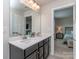 Bathroom with double vanity, large mirror and view into adjacent bedroom at 1607 Tundra Ln, Denver, NC 28037