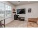 Bright bonus room with a large window, mounted television, shelving, and a comfortable couch at 1607 Tundra Ln, Denver, NC 28037