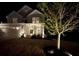 Charming two-story home with a manicured lawn and enhanced by landscape lighting at night at 1607 Tundra Ln, Denver, NC 28037
