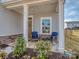 Inviting front porch with seating, stone accents, and a well-maintained landscaped garden at 1607 Tundra Ln, Denver, NC 28037