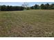 Large open grassy field with a house and trees in the background at 1714 Measmer St, Kannapolis, NC 28081