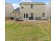 Large backyard with a patio that includes comfortable seating and a dining table set on a stone base at 176 Jennymarie Rd, Mooresville, NC 28115