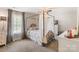 Light-filled bedroom featuring a canopy bed with soft bedding, large window, and neutral carpet at 176 Jennymarie Rd, Mooresville, NC 28115